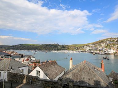 A view of rooftops overlooking a harbor with boats and hills in the background at 3 Dartview in Dartmouth