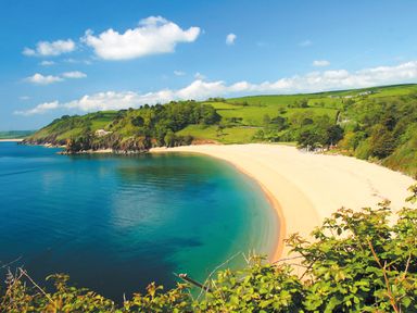 A beach with sand and clear water next to green hills and cloudy sky at 3 Dartview in Dartmouth