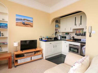 A living room with a television and kitchen area at 3 Dartview in Dartmouth