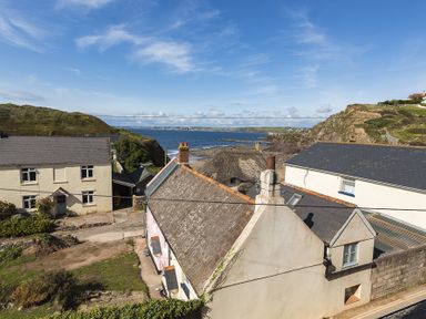 Houses near the coastline with cliffs and ocean in the background at 4 Armada House in Hope Cove