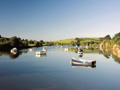 A river with several small boats and green hills in the background at Cowslip Cottage in Frogmore