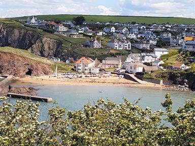A coastal village with houses on a hillside and a sandy beach by the sea at Cottage View in Hope Cove