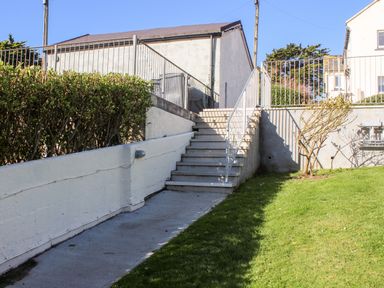 An outdoor area with stairs and a ramp next to a green lawn at Cottage View in Hope Cove