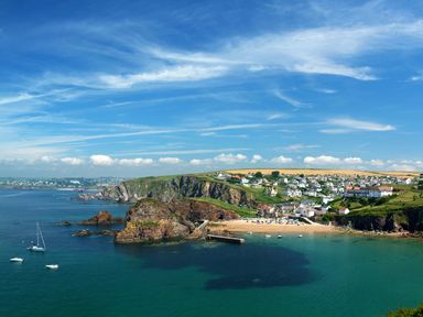 A coastal village with houses cliffs a sandy beach and boats on water at Cindys Retreat in Hope Cove