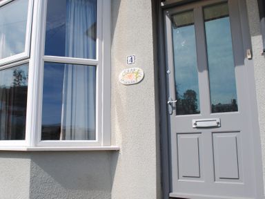 An entrance with a door and a window at Crab Cottage in Salcombe