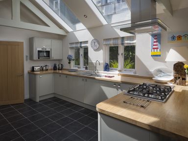 A kitchen with a wooden countertop gas stove and skylights at Gooder House in Dartmouth
