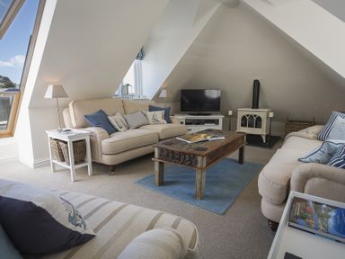 A living room with beige sofas a wooden coffee table and a television at Gooder House in Dartmouth