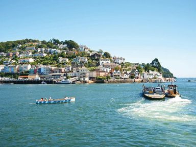 A coastal town with houses on a hill and boats on the water at Gooder House in Dartmouth