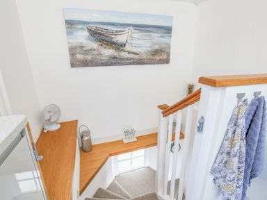 A staircase with carpeted steps a wooden handrail and shelving with decorative items at Kings View in Dartmouth