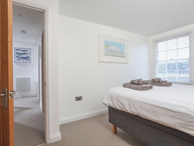 A bedroom with a bed and towels on it and a window with blinds at Kings View in Dartmouth