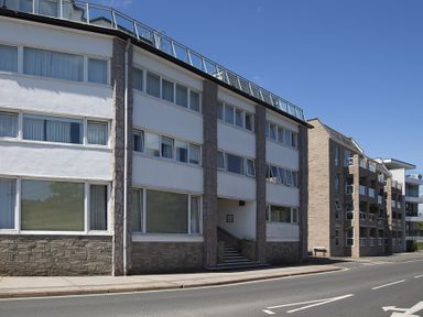 A street view with a multi story residential building complex and sidewalk at Leeside Dartmouth
