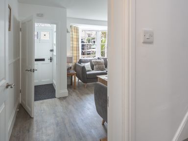 A hallway leading to a living room with couches near a window at The Old Wash House in Dartmouth