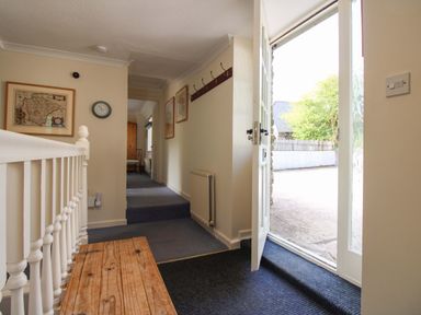 A hallway with a bench and door open at Orchard Barn Salcombe