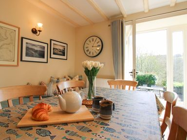 A dining room with a table set for tea at Orchard Barn Salcombe