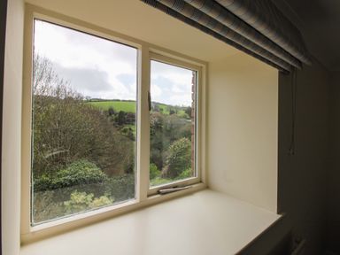 A window with a view of greenery at Orchard Barn Salcombe