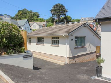 Exterior view of a single story house with a sloped roof and driveway at Rock Point in Salcombe
