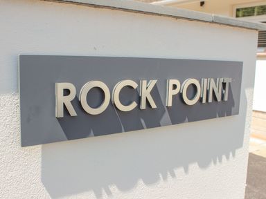 A sign with the text Rock Point on a wall at Rock Point in Salcombe