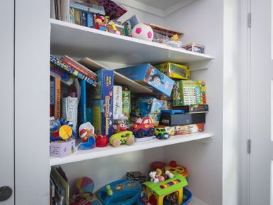 A white shelving unit filled with children's toys and games at Seaspray Bigbury-on-Sea
