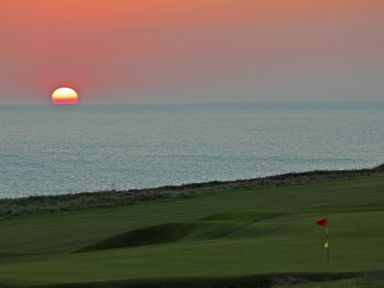 A golf course overlooking the sea at sunset at Seaspray Bigbury-on-Sea