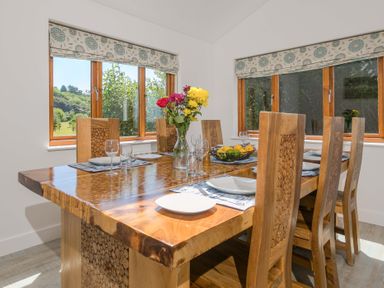 A dining room with a wooden table and chairs at Mellydonen Beder Del (Melly), Tor Down Quarry, St Breward