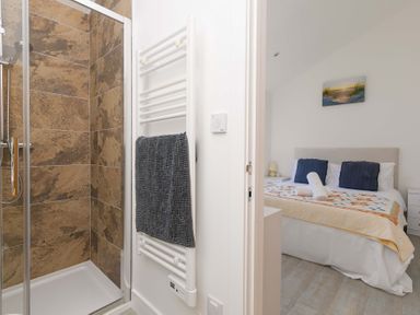 A bathroom with a shower and a view of a bedroom at Mellydonen Beder Del (Melly), Tor Down Quarry in St Breward