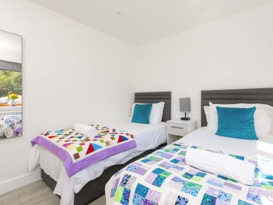 A bedroom with two beds and a mirror at Mellydonen Beder Del (Melly), Tor Down Quarry, St Breward