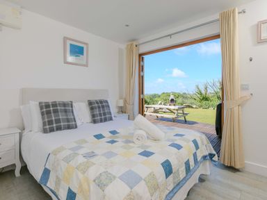 A bedroom with a bed and outdoor view at Mellydonen Beder Del (Melly), Tor Down Quarry, St Breward