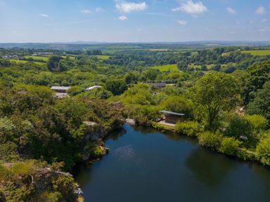 A scenic view of a lake and greenery at Mellydonen Beder Del (Melly), Tor Down Quarry St Breward