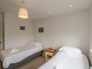 A bedroom with two single beds a nightstand and a hanging light at 7 Dale End Danby near Castleton