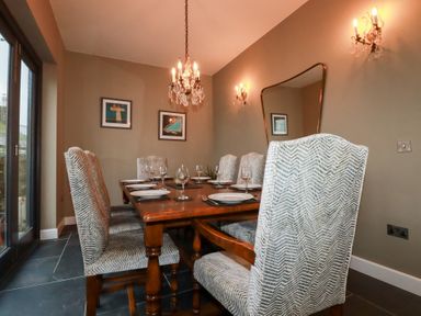 A dining room with a wooden table and chairs at Postcard Lodge in Polruan