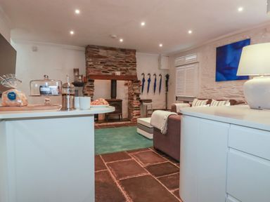 A living room with a sofa and fireplace at Rock House near Trebarwith Strand near Tintagel