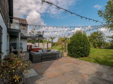 An outdoor patio area with string lights seating arrangement and plants at Longmynd in Gloucester