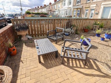 A garden area with chairs and a table at Beach Cove View in Newbiggin-by-the-Sea