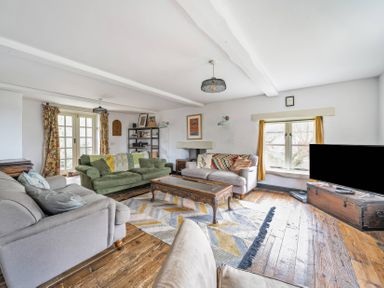 A living room with a sofa, coffee table, and television at Spring Park Farmhouse in Launceston
