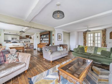 A living room with sofas, a coffee table and a dining table at Spring Park Farmhouse in Launceston