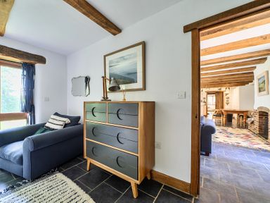 A living room with a sofa and chest of drawers at Woodcutters in Rezare near Launceston