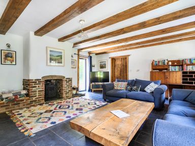 A living room with a fireplace and bookshelves at Woodcutters in Rezare near Launceston