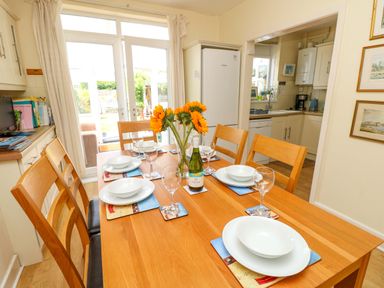 A dining room with a table set for a meal at 32 Cranleigh Close Tuckton