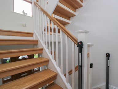 A staircase with wooden steps and banister at Langtree in Arnside