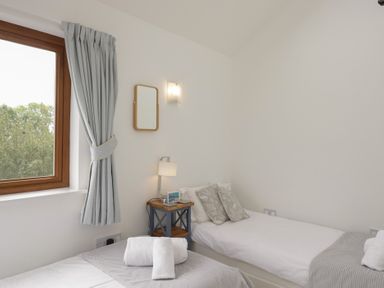A bedroom with two beds and a window at Langtree in Arnside