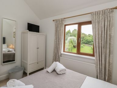 A bedroom with a bed and wardrobe at Langtree in Arnside