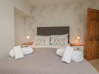 A bedroom with a bed and towels at Langtree in Arnside