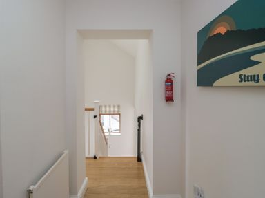 A hallway with staircase and window at Langtree in Arnside