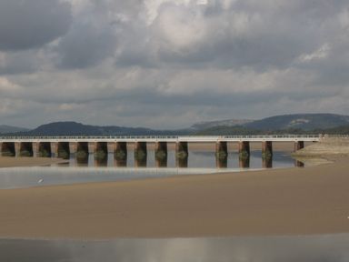A bridge over water with sandy shore at Langtree in Arnside