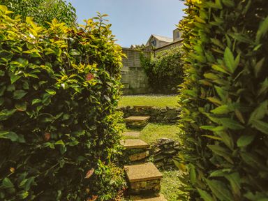 A garden path with stone steps surrounded by hedges at 1 Lyndhurst in Salcombe