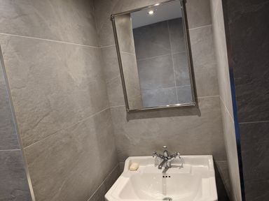 A bathroom with a sink a bar of soap a mirror and tiled walls at Rose Cottage in Lowick Bridge