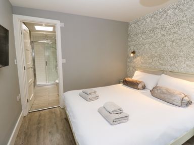 A bedroom with a double bed and an en suite bathroom at Restharrow Lodge in Bamburgh