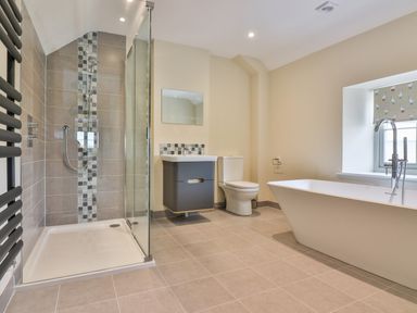 A bathroom with a glass shower enclosure a bathtub a toilet and a sink at The Retreat in Lympsham