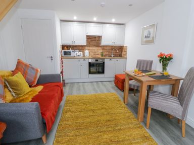 A small living room with a sofa table and kitchenette at Bwlch Y Gwynt Bach in Llangefni