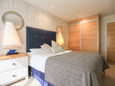 A bedroom with a bed and side tables with lamps in Quayside Dart Marina Dartmouth